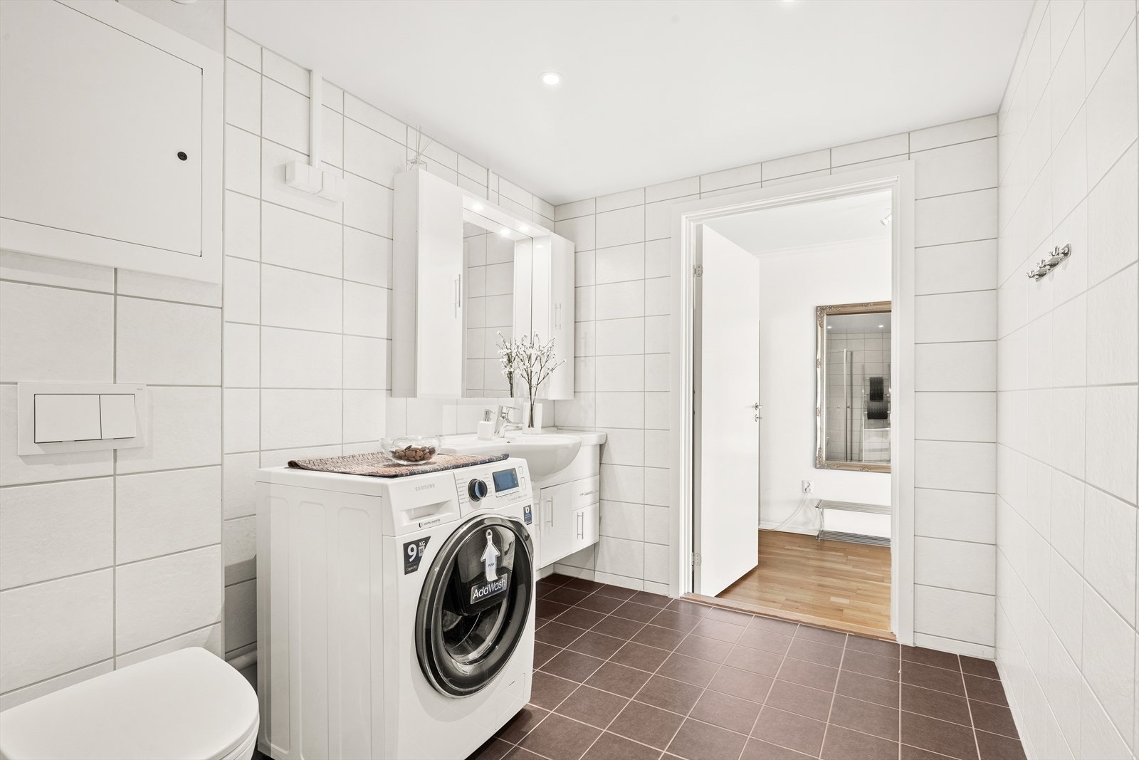 Innredning med vegghengt toalett, servantinnredning og dusj på gulv med innfellbare glassdører. Opplegg til vaskemaskin. Varmekabel i gulv. Galleribilde