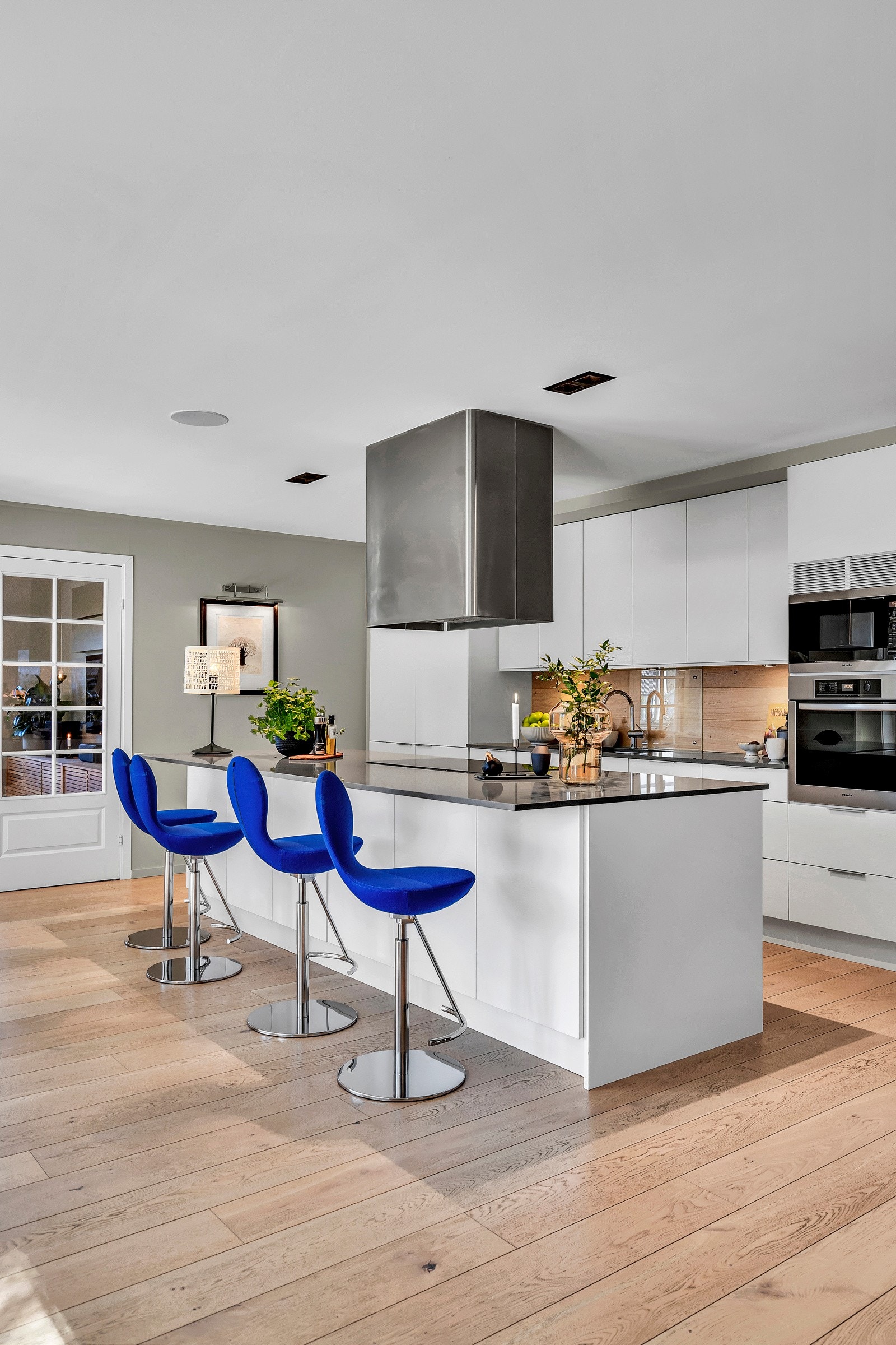 Kjøkkenøy med sitteplasser og koketopp. Legg merke til intergret høyttaleranlegg fra Sonos, totalt 5 separate soner i huset. Galleribilde