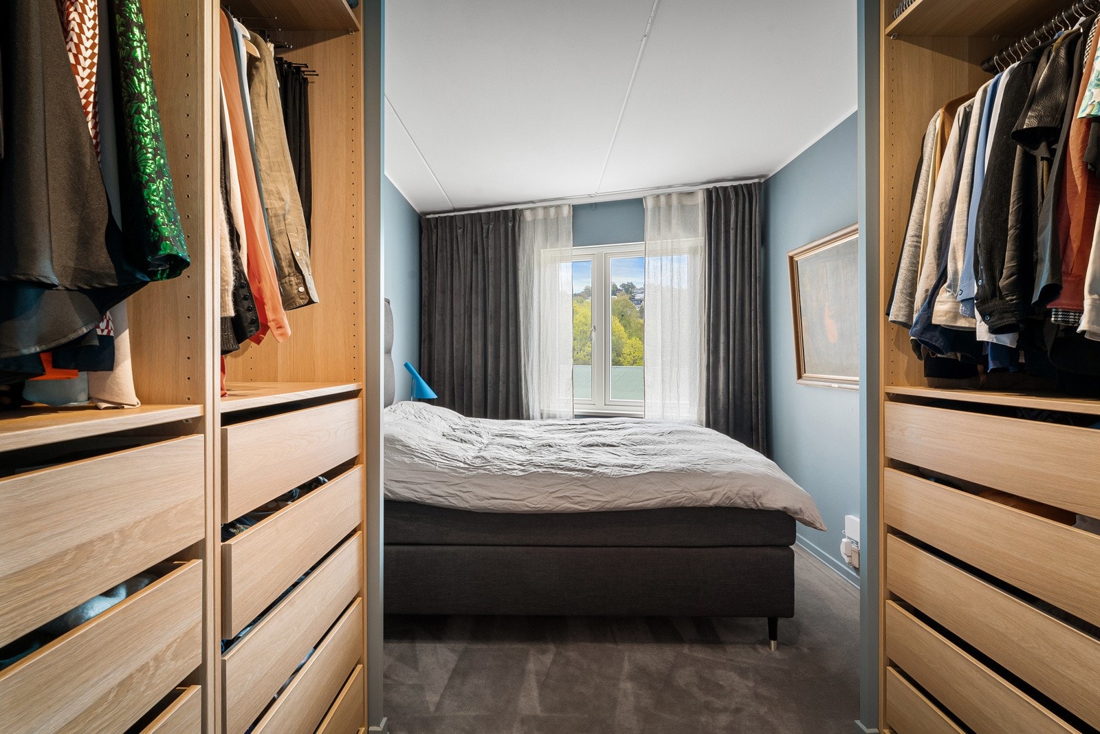 Hovedsoverommet har gråfarget vegg-til-vegg teppe fra 2020 og åpne garderobeløsninger på hver side av døren. Galleribilde
