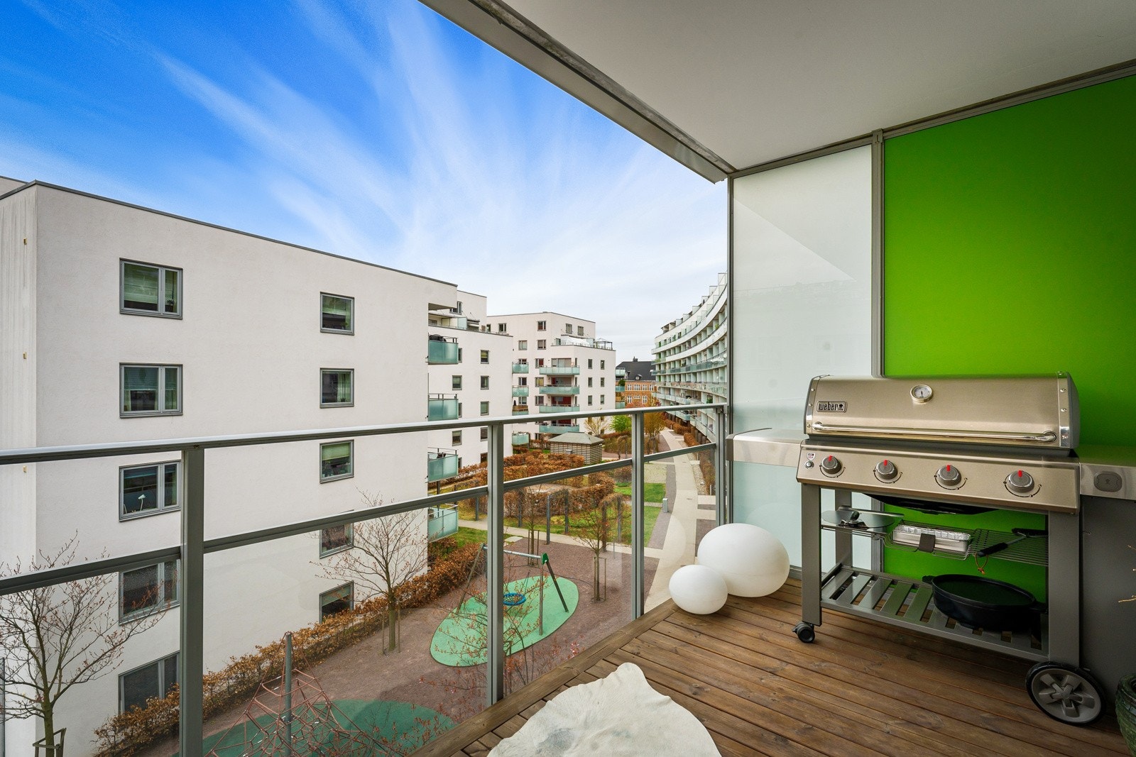 På balkongen er det dekke av terrassebord over støpt betongdekke og levegg i frostet glass mot nabobalkongen. Resten av balkongen innrammes av et rekkverk i glass som gjør det luftig og fint, overbygget gjør at balkongen kan benyttes om det regner litt. Galleribilde