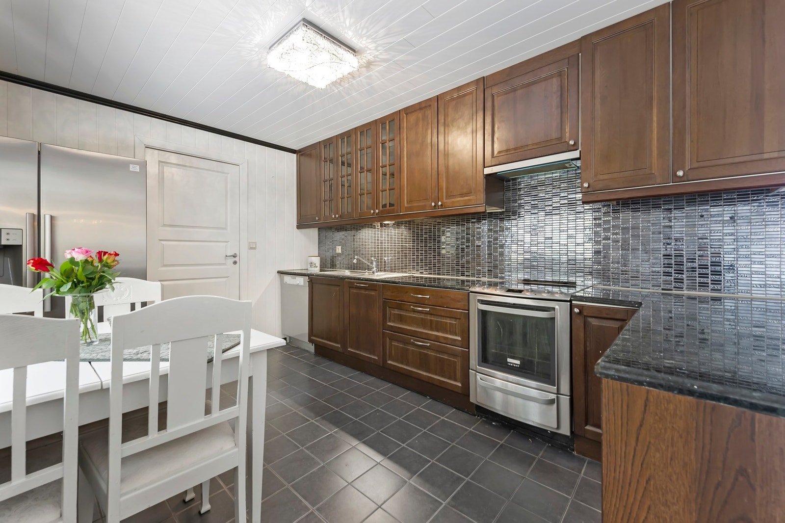 Romslig kjøkken med frittstående hvitevarer og god plass til spisebord Galleribilde