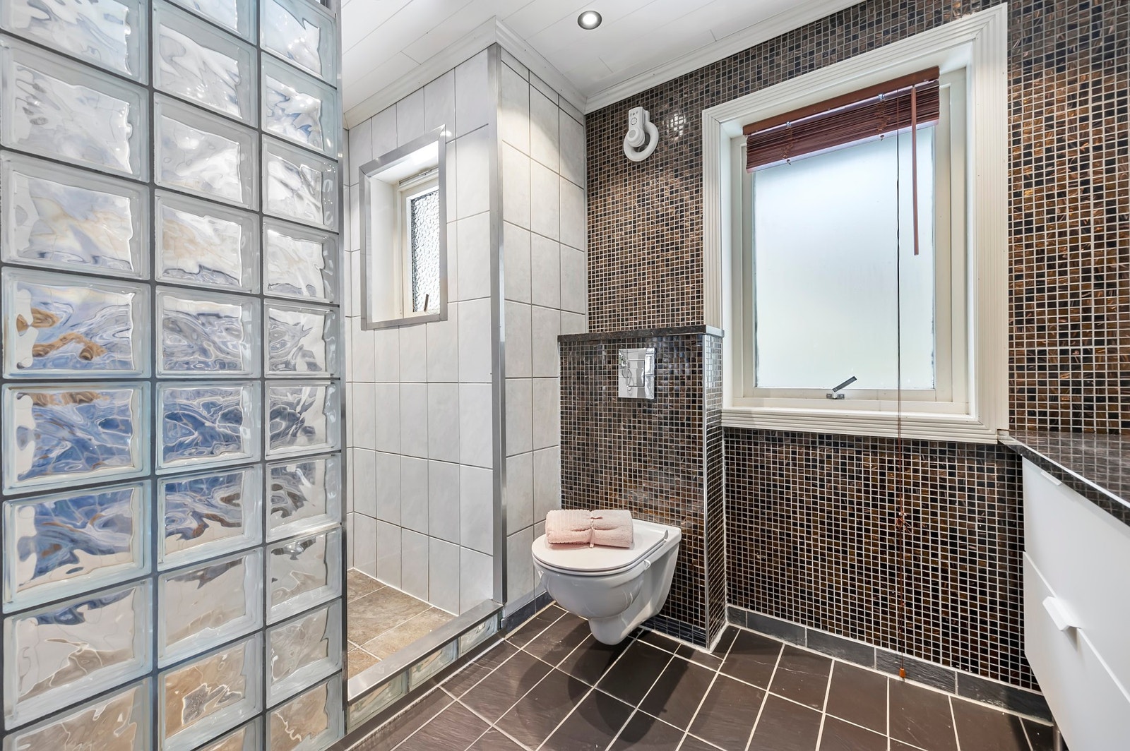 Badet har vegghengt toalett og dusjnisje Galleribilde