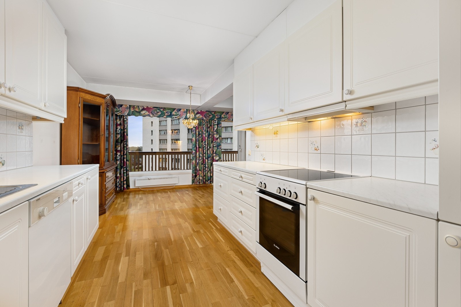 Kjøkkeninnredningen har profilerte fronter og benkeplate i laminat med nedfelt oppvaskkum. Det er flislagt mellom kjøkkenbenk og overskap for enkelt renhold. Galleribilde