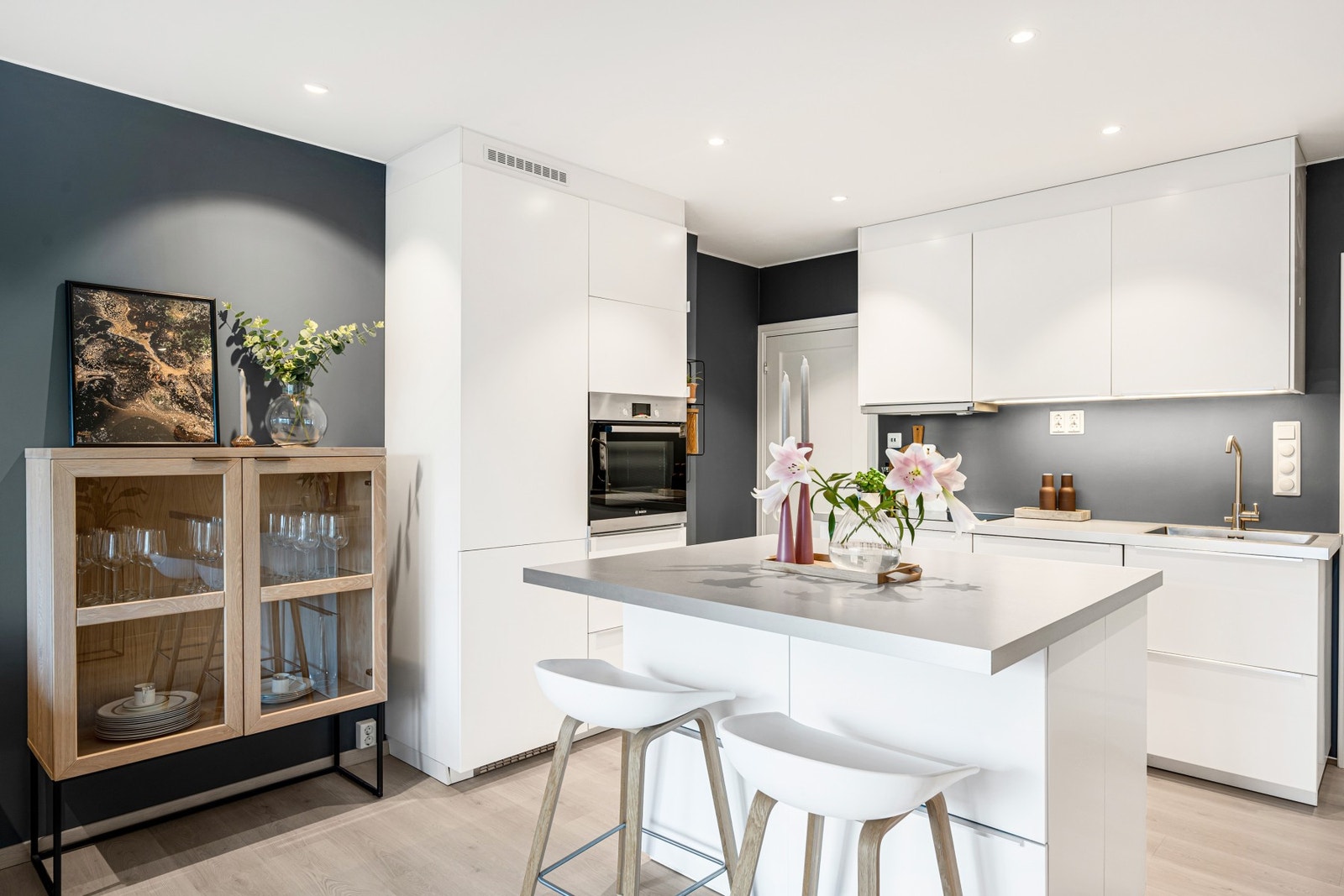 Stilrent kjøkken med praktisk kjøkkenøy og barløsning. Hele leilighetens EL-anlegg, i tillegg til sikringsskap, er også nytt fra 2017. Galleribilde