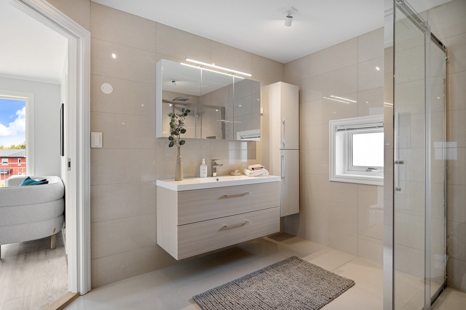 Badet har tidløse fliser og downlights-belysning i himlingen Galleribilde