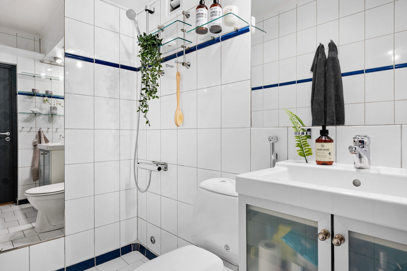 Badet er utstyrt med toalett, dusj, servant med innredning og varmekabler i gulvet. Integrerte speil på vegger. Galleribilde