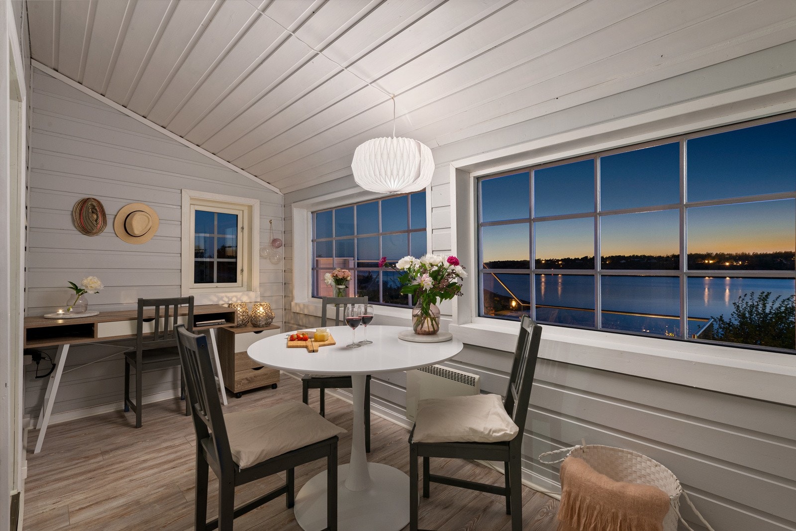 Utgang til en vestvendt terrasse og hage med svaberg og bugnende beplantning Galleribilde