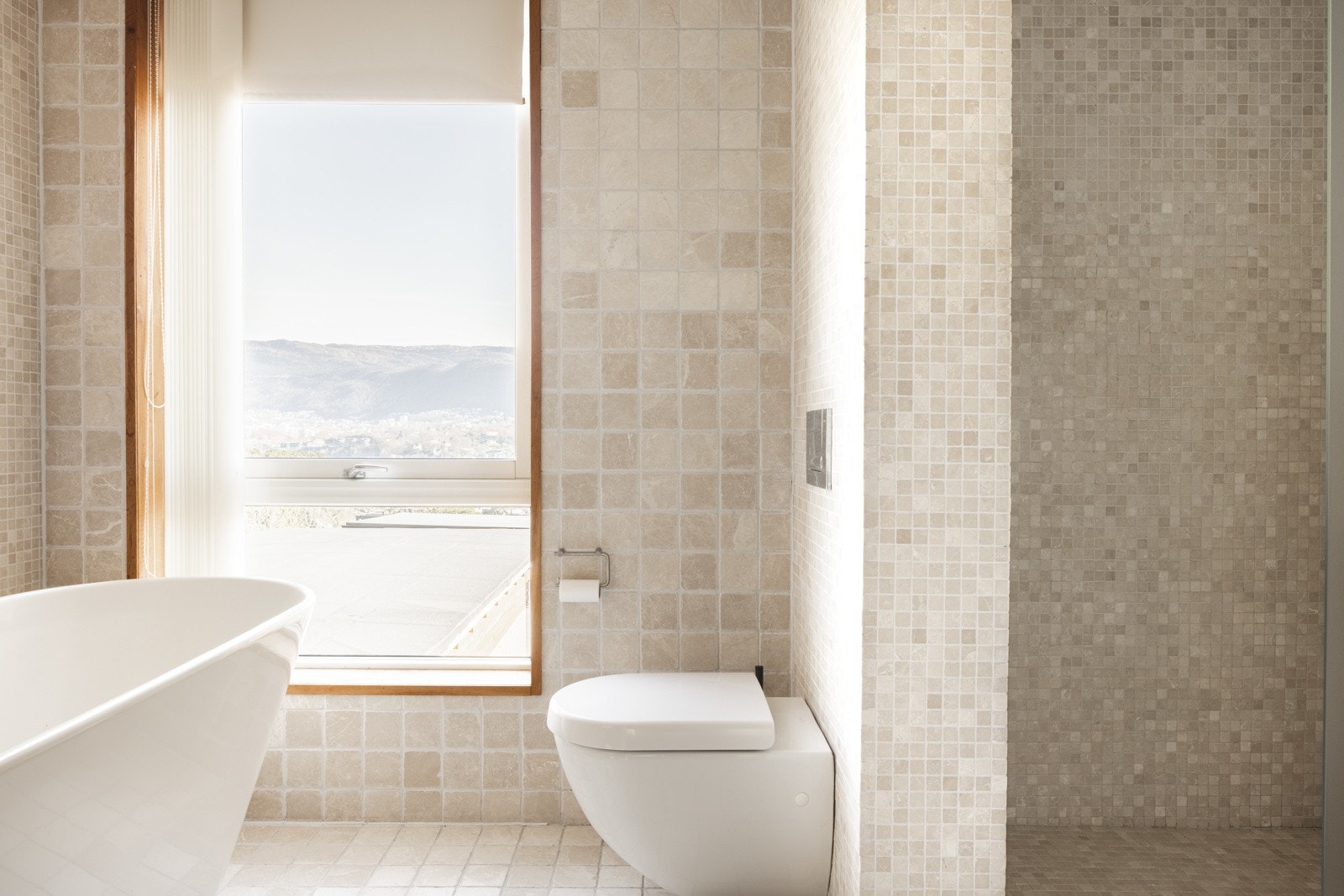 Utsikt fra badet via stort vindu innrammet i teak | Badekar og dusjnisje Galleribilde