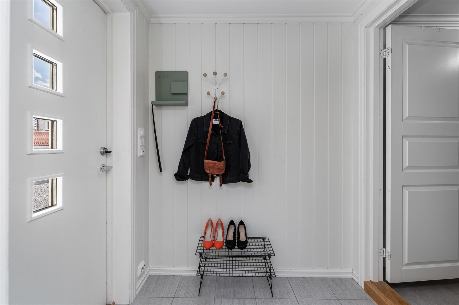 Lys og hyggelig entre som ønsker velkommen inn, hvor det er plass til sko og yttertøy Galleribilde