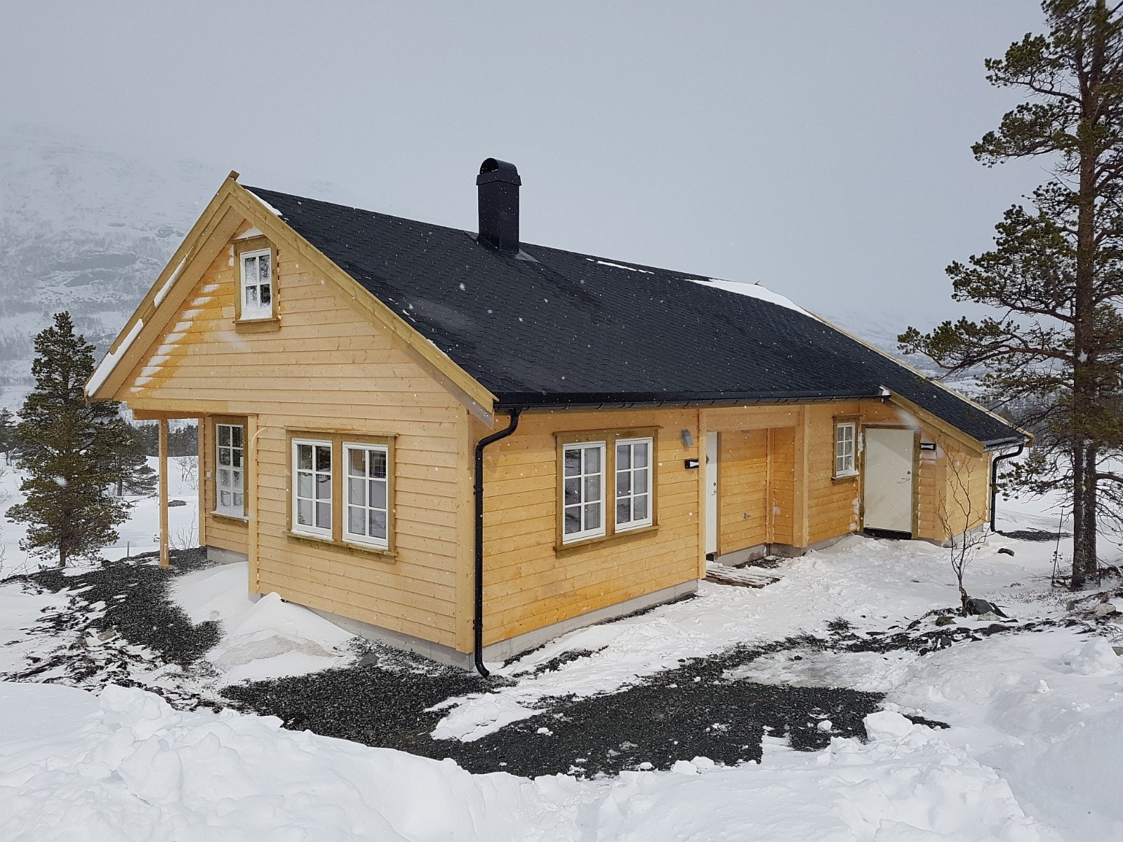 Vinterbilde av Berakupen med enkelfalset kledning og shingeltak Galleribilde