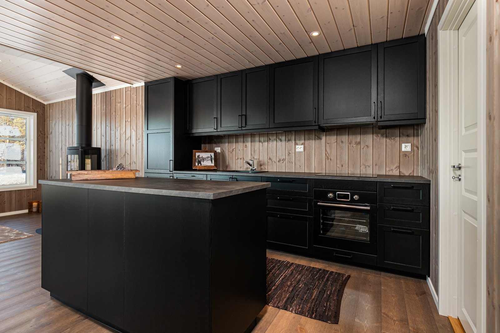 Både stuen, kjøkkenet og spiseplassen er bygget som et stort oppholdsrom rundt peisovnen. Galleribilde