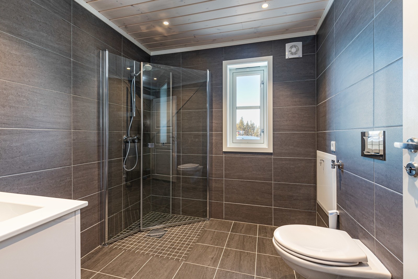 På badet leveres det fliser på vegger og gulv. Det kan velges mellom ulike utvalgte fliser, formater og overflater. Galleribilde