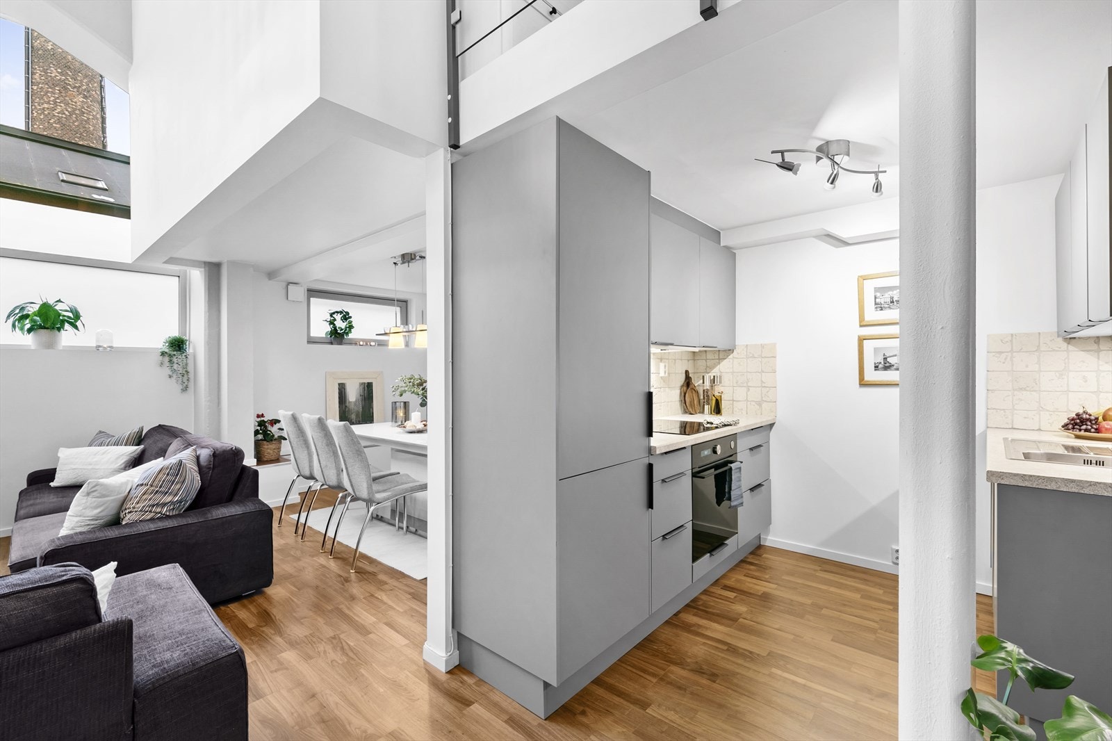 Stue og kjøkken i sosial, delvis åpen løsning. Galleribilde