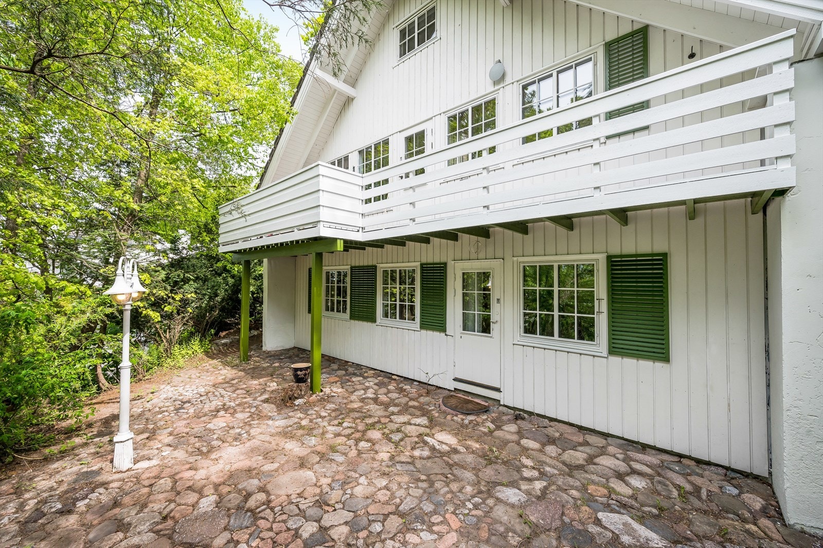 Fasade mot vest, med utgang fra soverom til steinsatt uteplass med utelys. Galleribilde