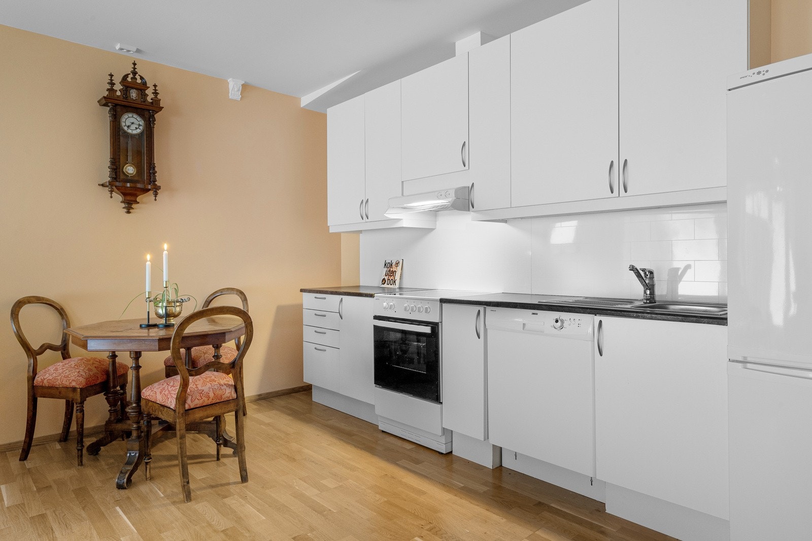 Moderne og tidløst kjøkken i praktisk utforming langs vegg Galleribilde