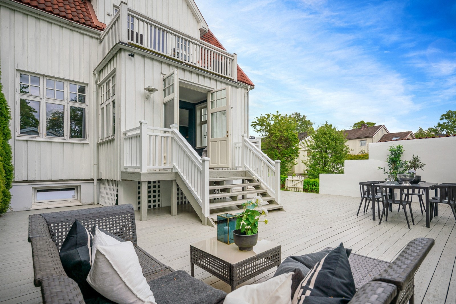 Terrassen skjermes med hvitmalte murvegger og høyreist hekk. Galleribilde