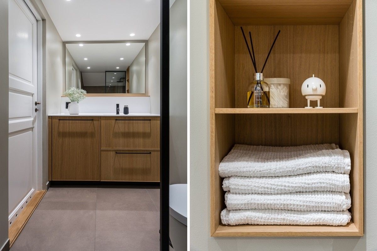 Servantinnredning med trefronter og heldekkende Corian plate med integrert vaskemaskiin. Snekkerbygget hylle over toalett. Galleribilde