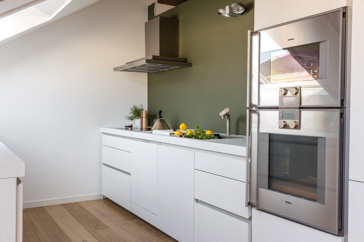 Eksklusiv kjøkkeninnredning fra Bulthaup med kompakt laminat benkeplater, skuffer i bjørk og grepsfrie fronter Galleribilde