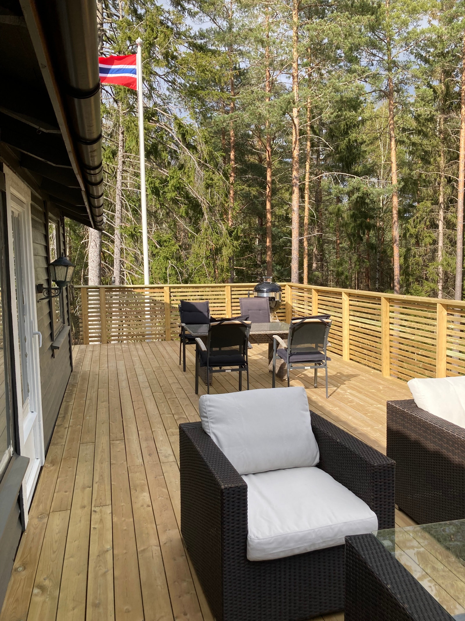 Terrasse forside med kullgrill hengekøye og parasoll. Galleribilde