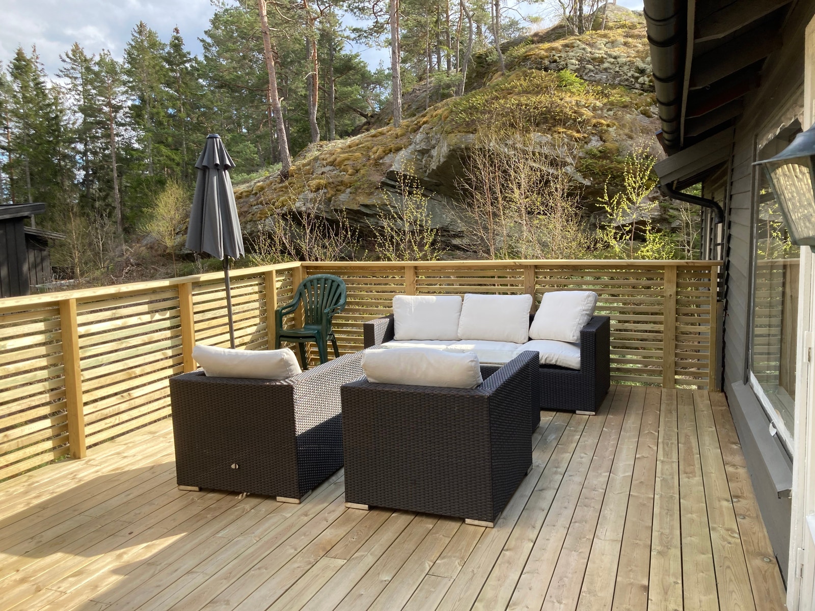 Terrasse forside med kullgrill hengekøye og parasoll. Galleribilde