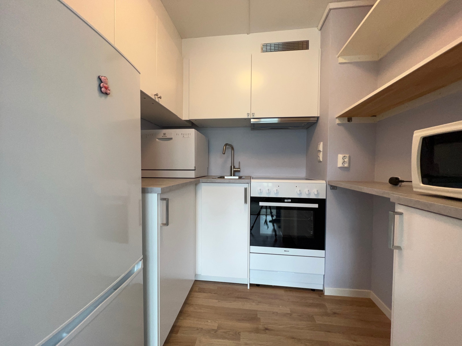 Kjøkken med kombiskap, komfyr og mikroovn Galleribilde