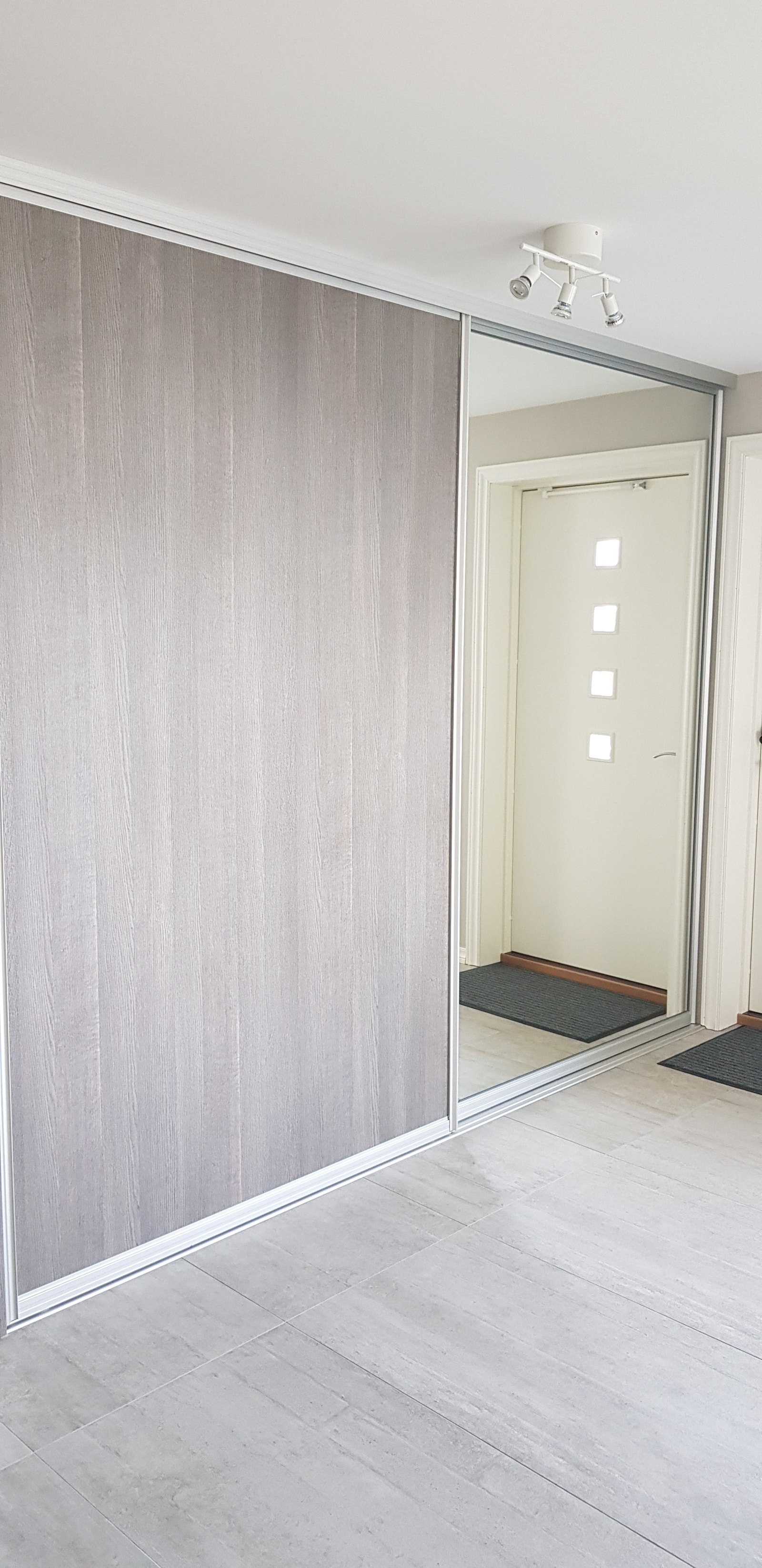 Stor skyvedørsgarderobe med mange trådkurver for oppbevaring ved inngangen. Galleribilde