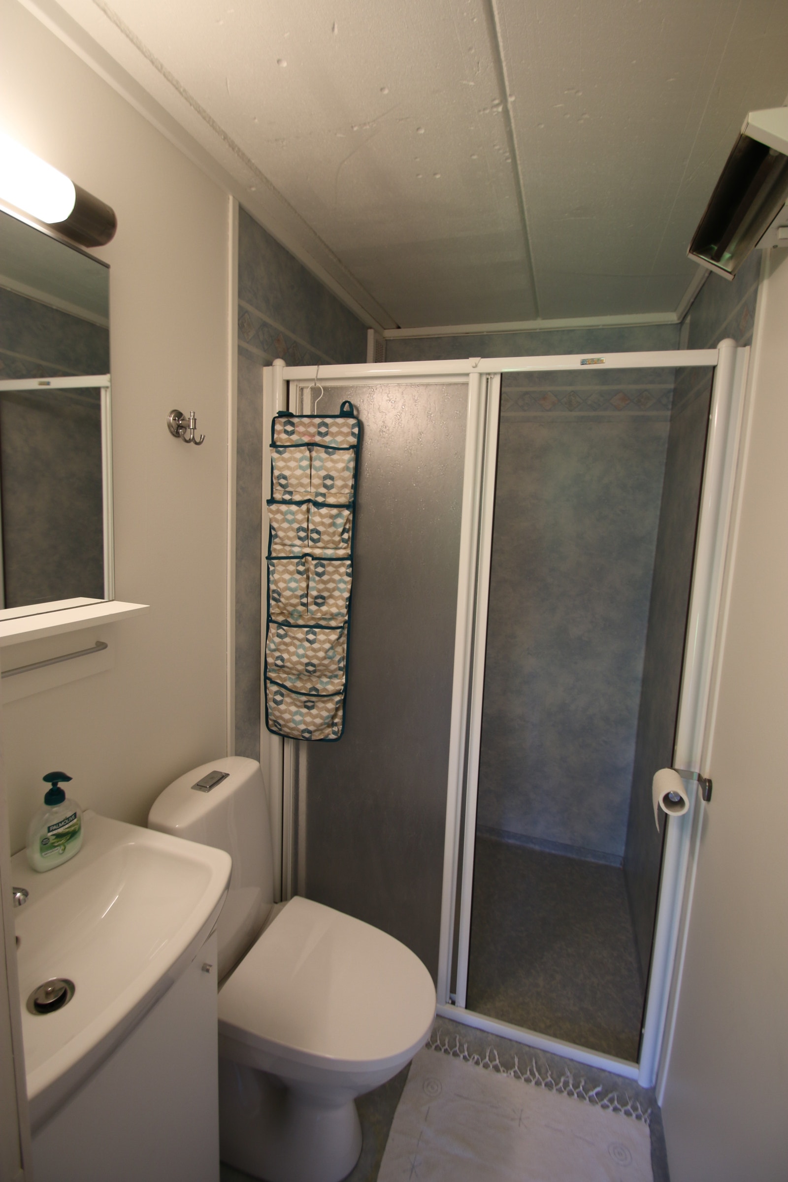 Bad med stor dusj, belegg på gulv, varmeovn på vegg (ikke varmekabler i gulv). Galleribilde