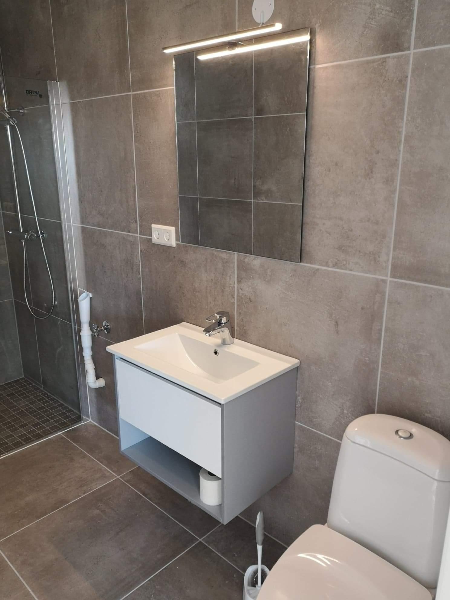 Badet er flislagt og har stort dusjområde. Galleribilde