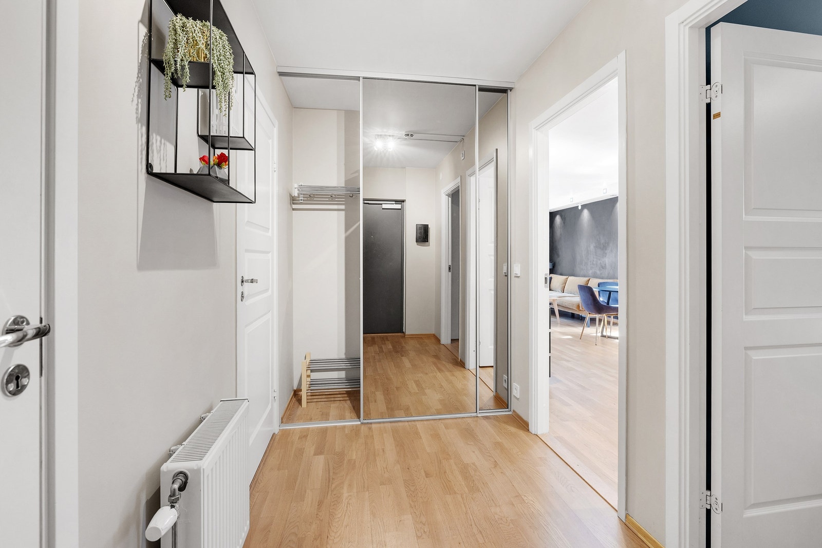 Lys og innbydende entré med skyvedørsgarderobe. Galleribilde
