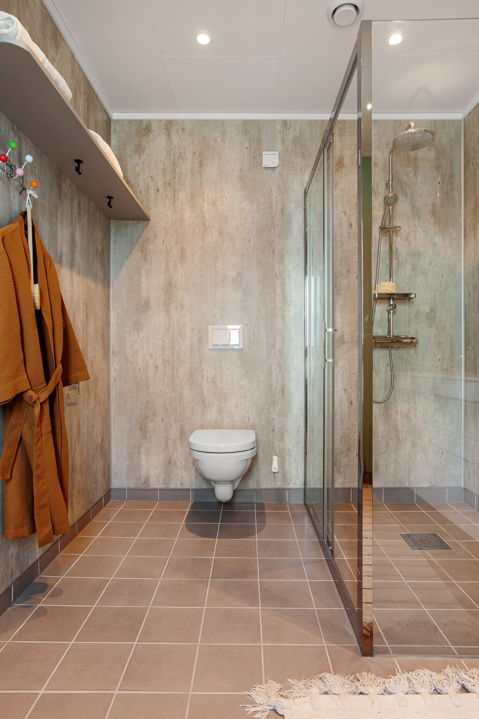 Stilige og moderne farge- og materialvalg. Badet har vegghengt toalett og dusjhjørne.