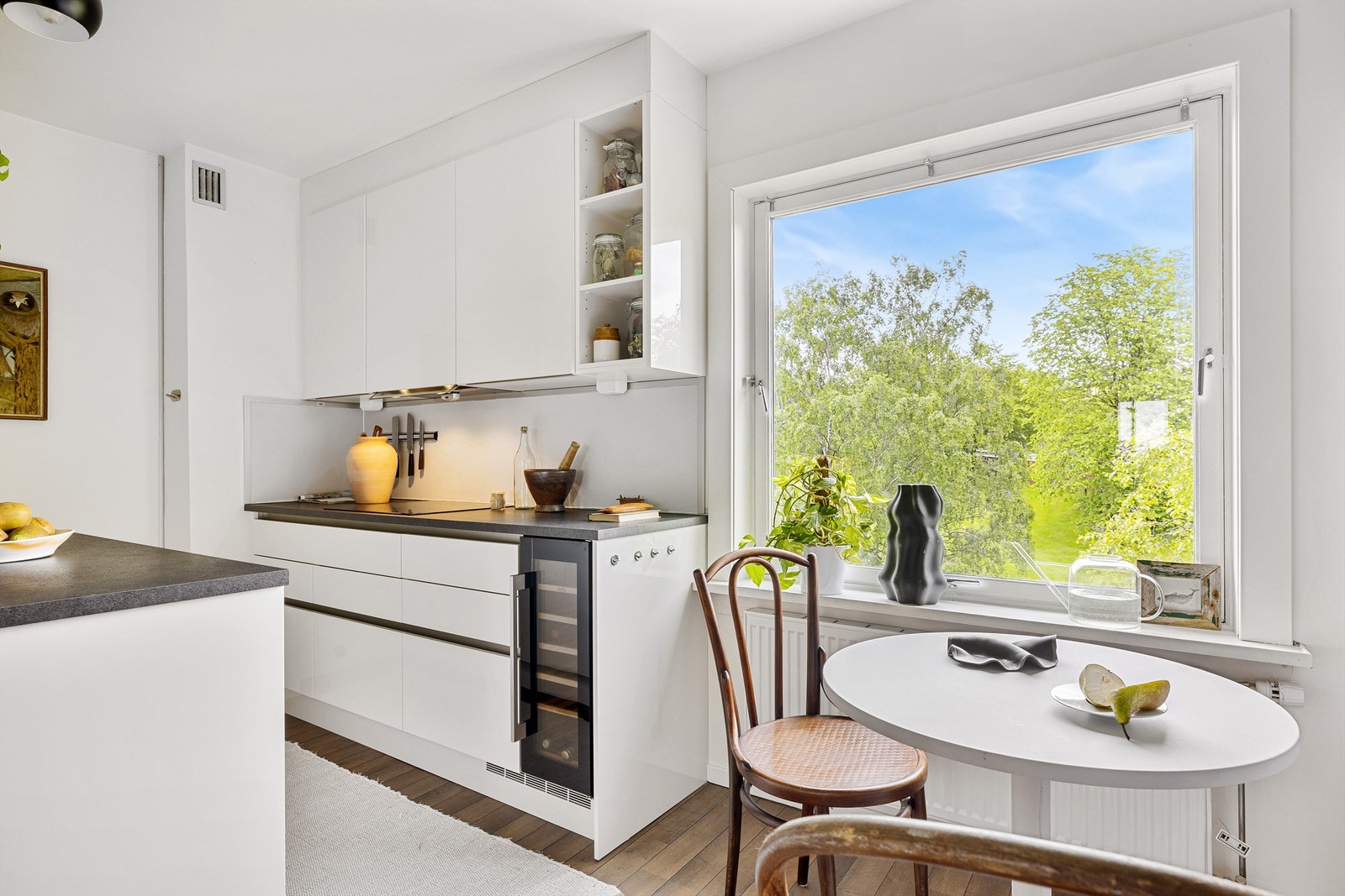 Koselig spiseplass ved vinduet med utsyn til grøntareal Galleribilde