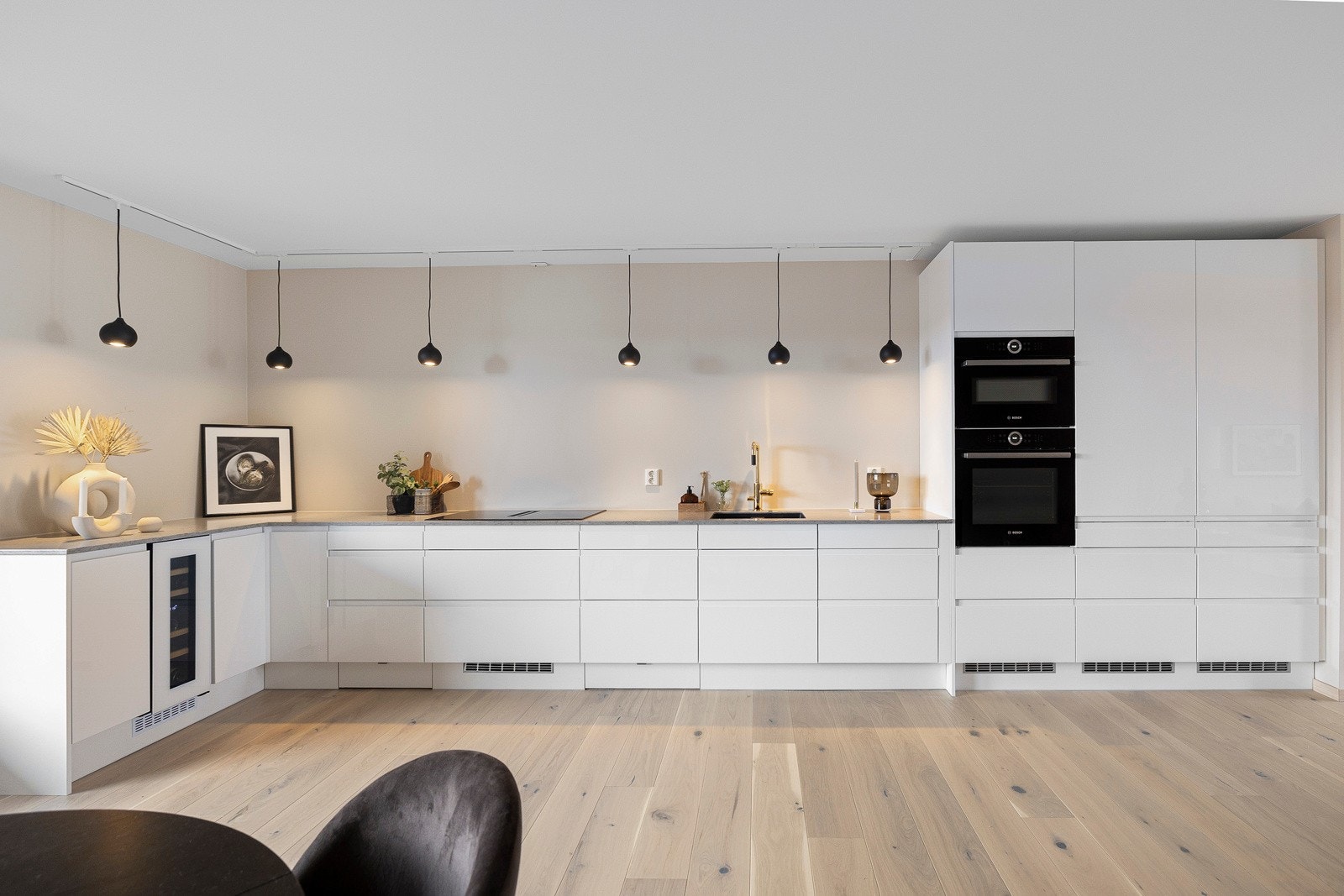 Over en lekker benkeplate i stein er det høyaktuell designbelysning, og ved en underlimt kum i sort kompositt er det stilfullt, gullfarget armatur Galleribilde