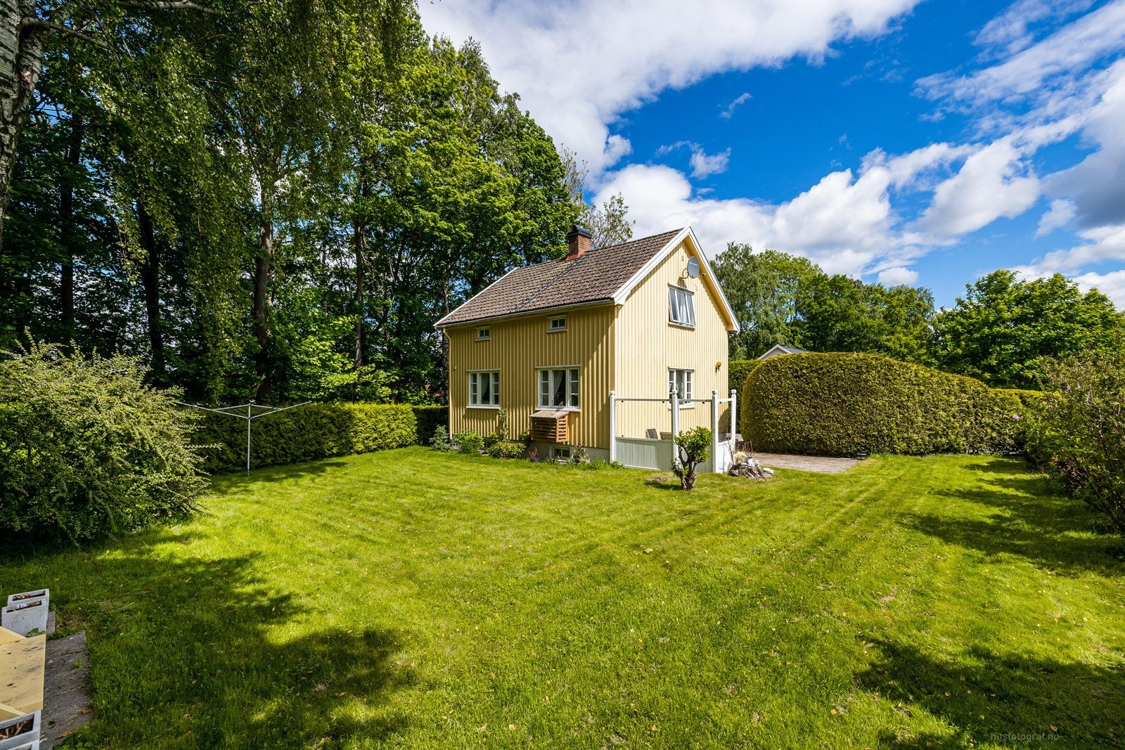 Tomten er pent opparbeidet med gressplen og beplantninger Galleribilde