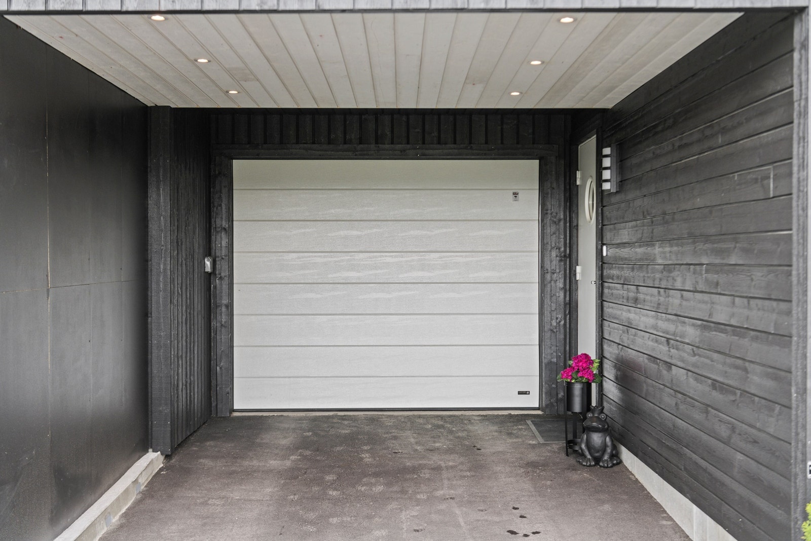 Carport med downlights foran garasje. Her kan begge bilene stå fri fra snø og is. Galleribilde
