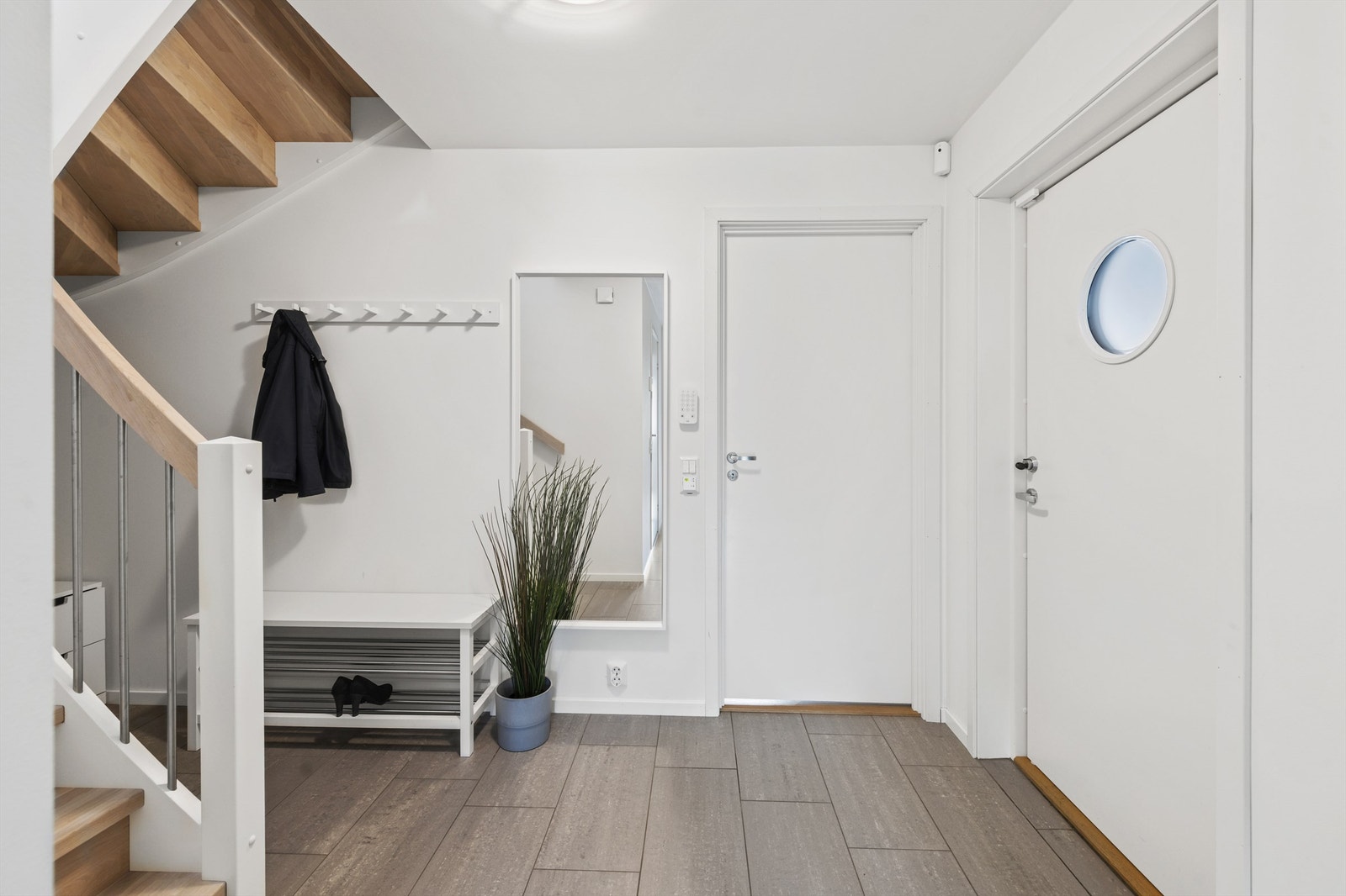 Det er god plass til å henge fra seg yttertøyet. Mulighet for ytterligere oppbevaring under trappa Galleribilde