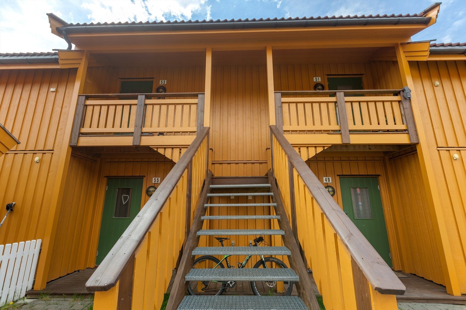 Steinlagt inngangsparti med trapp opp til inngangsdøren. Galleribilde