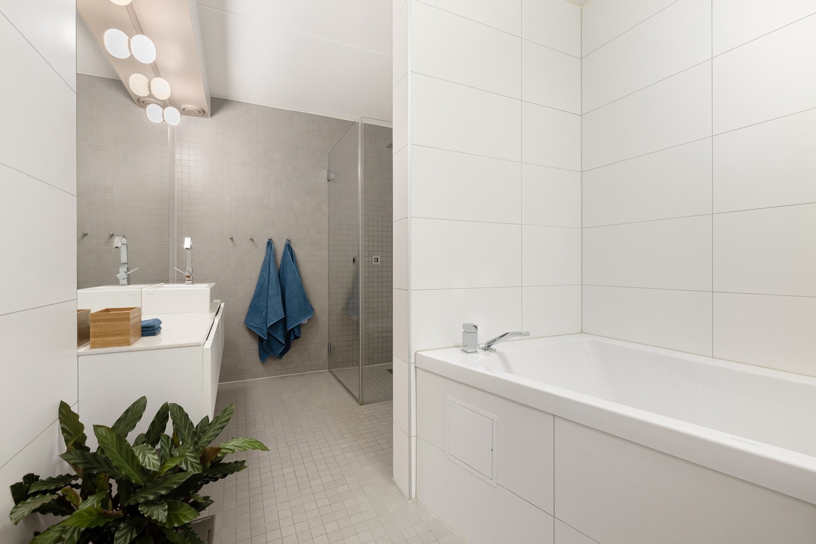 Innholdsrikt og godt utnyttet bad med flislagte gulv og vegger, varmekabler og pen innredning. Galleribilde