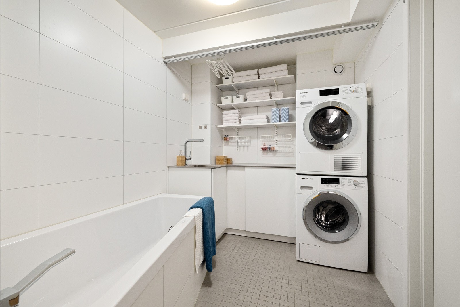 Badet har også fint opplegg for vaskemaskin og tørketrommel. Gode oppbevaringsløsninger i skap og hyller. Galleribilde