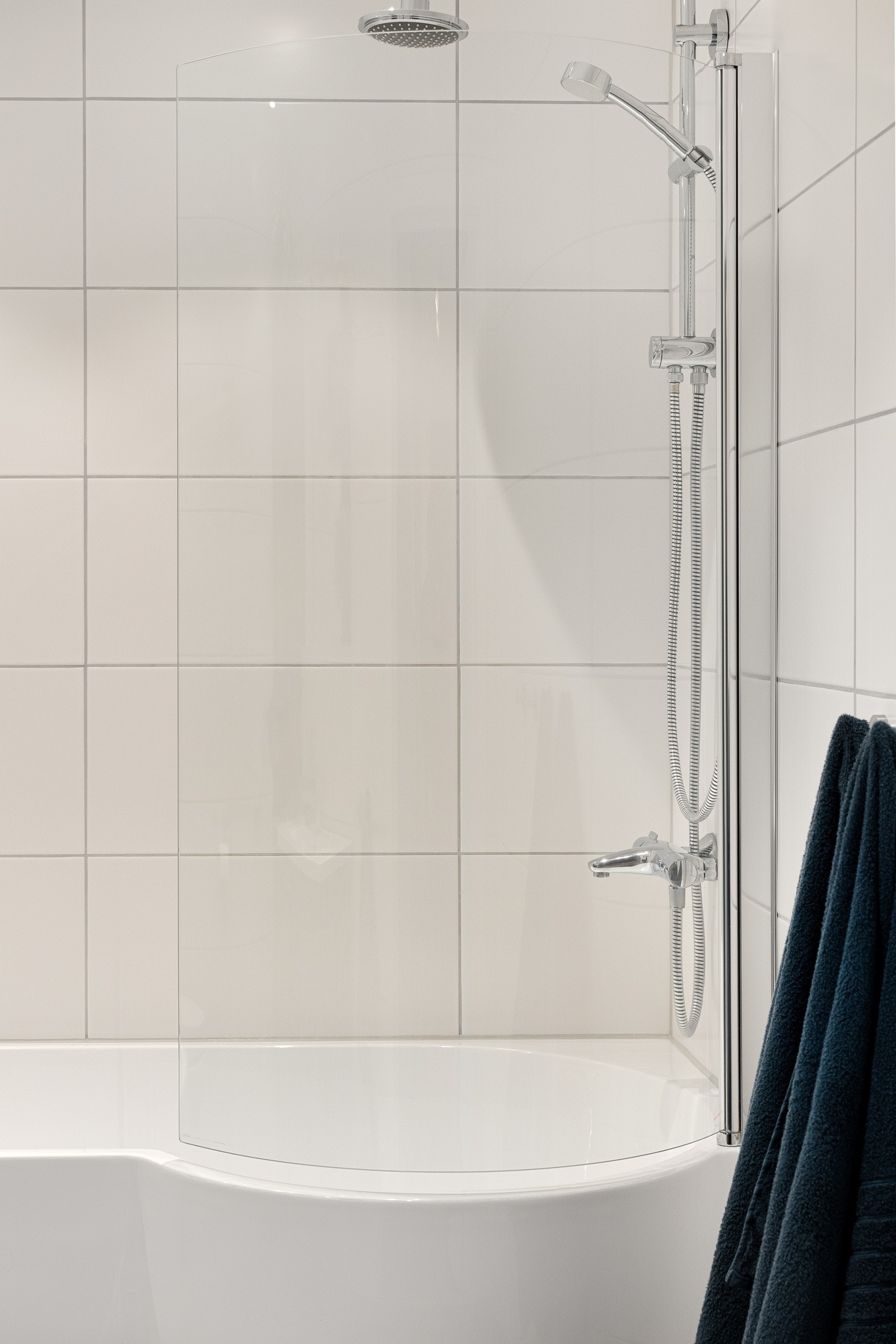 Badet har badekar med badekarsvegg i glass og armatur med både regnfallsdusj og hånddusj. Galleribilde