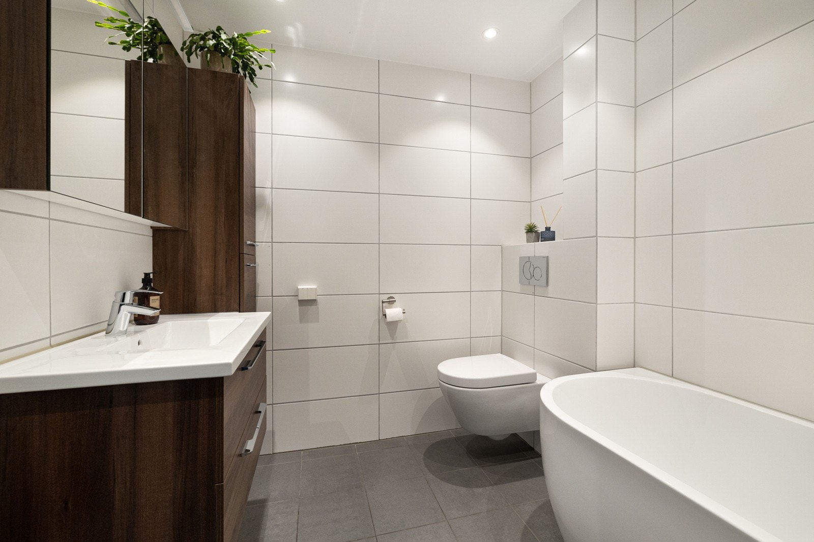 Delikat bad med flislagt gulv med varmekabler. Oppbevaringsplass i servantskap med skuffer, høyskap og speilskap. Galleribilde