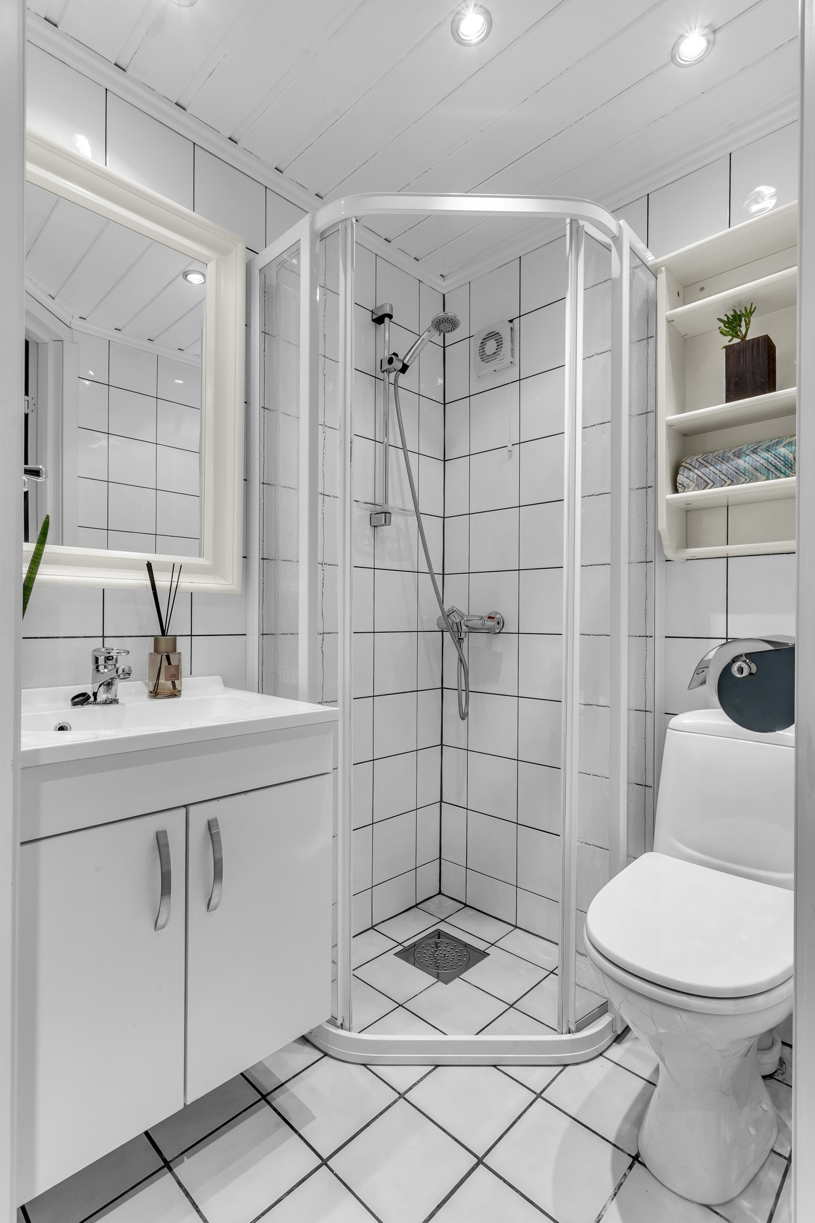 Badet i u.etg er innredet med hvite vegg- og gulvfliser. På badet er det gulvvarme og downlights i himlingen. Galleribilde