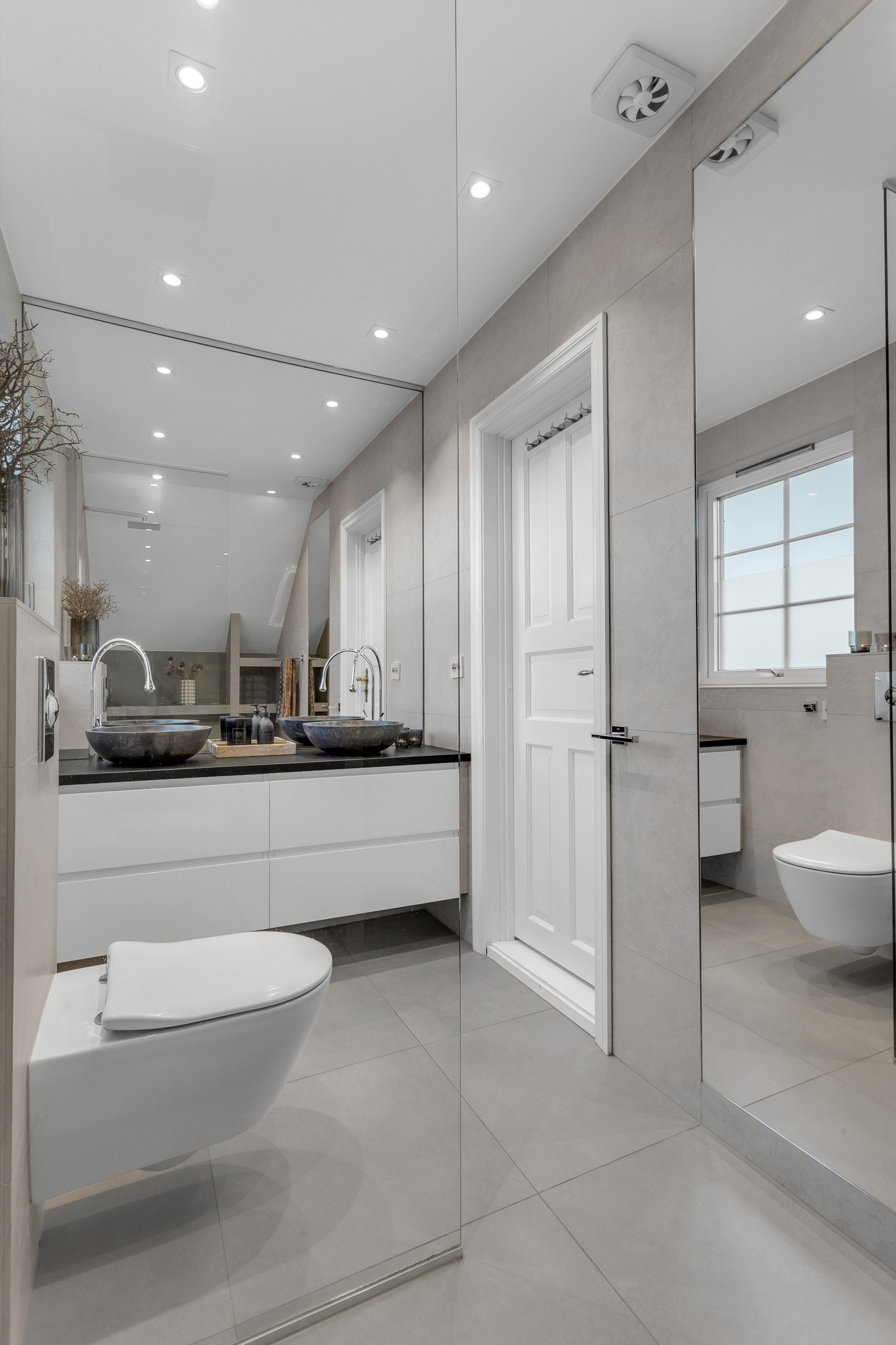 Badet oppe er stilrent med store, sandfargede vegg- og gulvfliser. Utstyrt med gulvvarme, vegghengt toalett og downlights i himlingen. Galleribilde