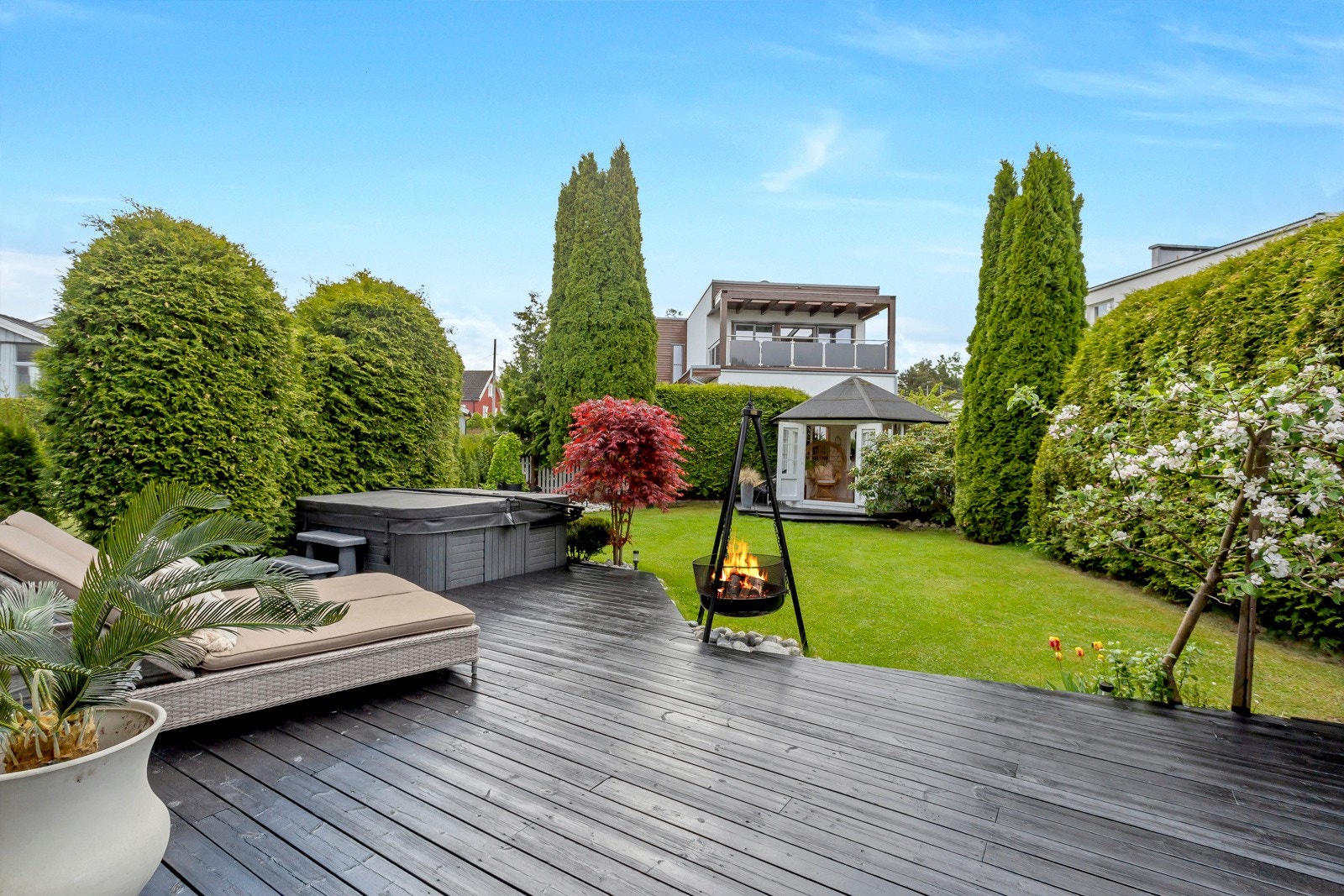 Både huset og hagen rammes flott inn av elvestensbed med vakre prydbusker hagehortensia, rhododendronbusker, viftelønn og smaragd-thuja. Galleribilde