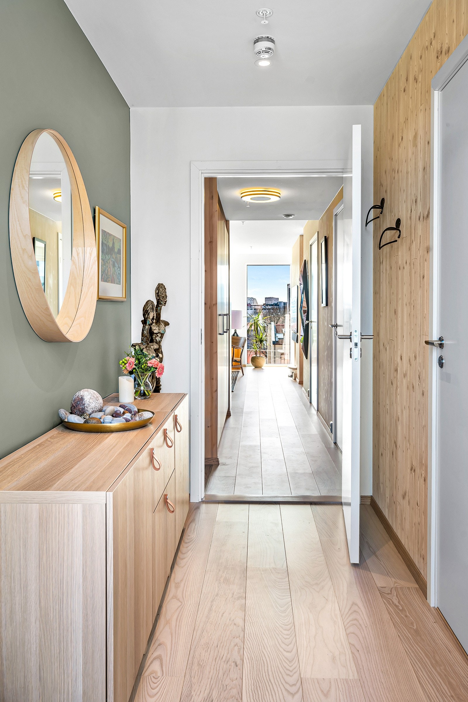 Plassbygd garderobeskap fra HTH i samme stil som kjøkken plassert i mellomgang gir godt med lagring, i tillegg til praktisk innvendig bod på motsatt side Galleribilde