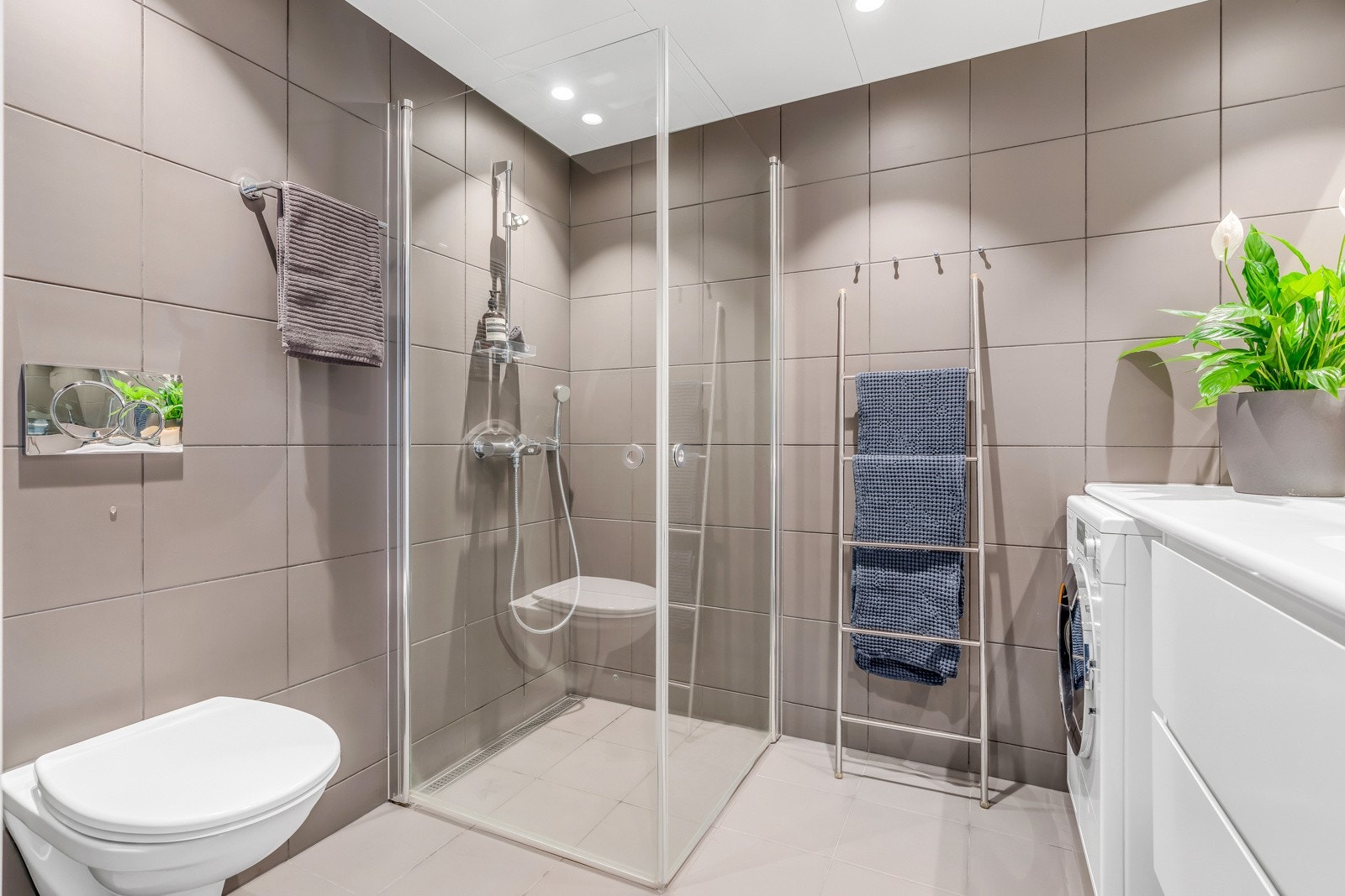 Den flislagte badet har et moderne uttrykk med kvalitetsinnredningen du trenger - det blir i dag lagt nye lekre 30x30 Greco Glade gulvfliser i fargen Branco samt mosaikkfliser i dusjsone Galleribilde