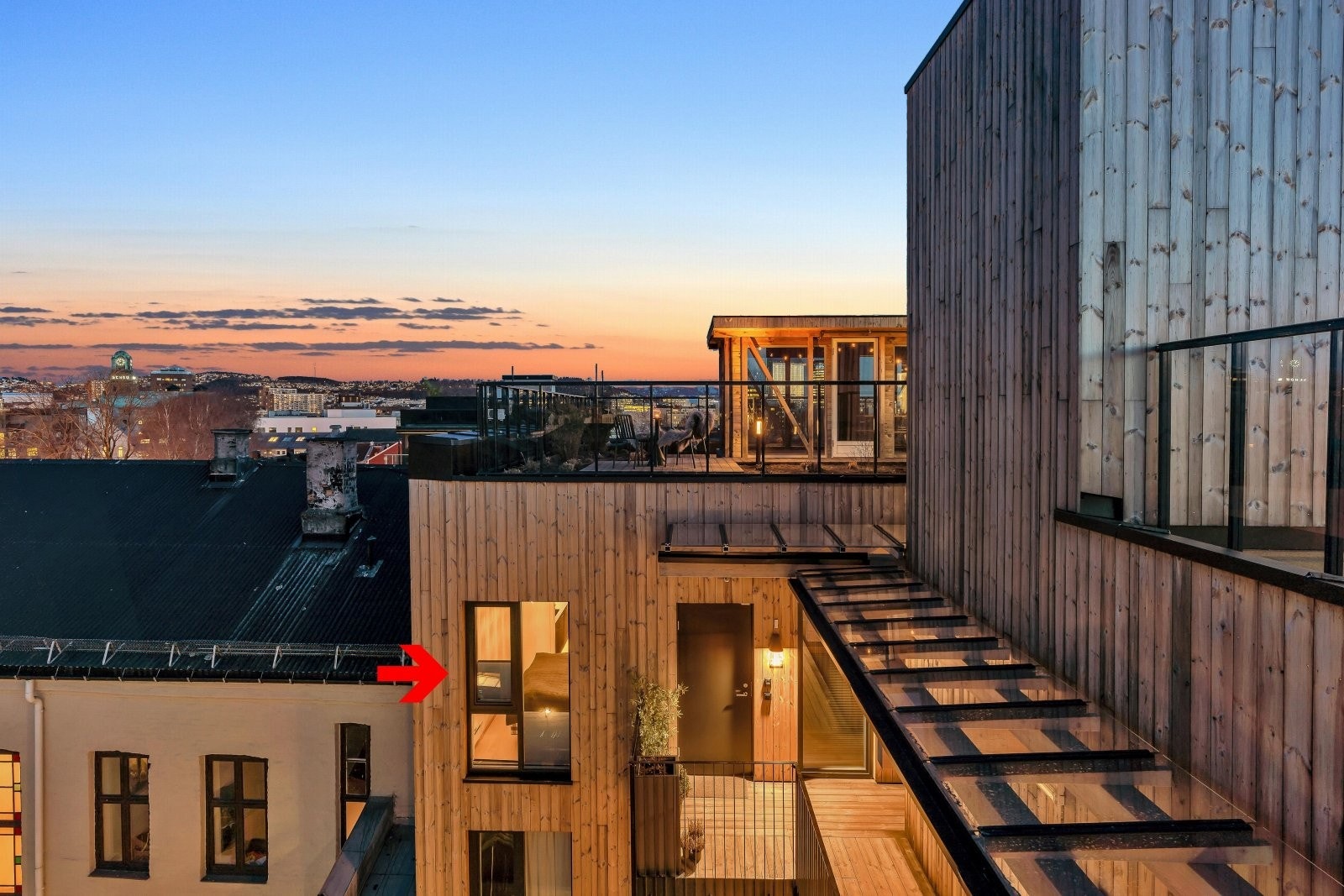 Kun én trapp opp finner du den flotte takterassen på 550 kvm som har spektakulært byutsikt i alle retninger med sol fra tidlig på morgen til seint på kvelden. Her ser du inngangsparti til boligen fra terrassen Galleribilde