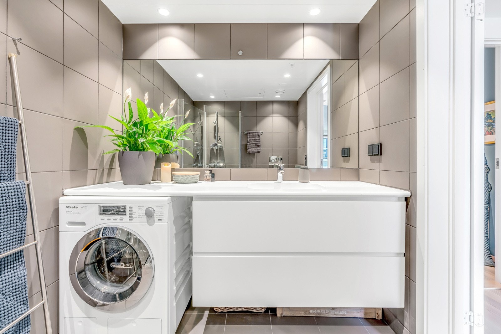 Baderomsinnredningen består av helstøpt servant på underskap med skuffer samt speil på overside. Videre har du fasiliteter som vegghengt toalett og dusjhjørne med svingbare vegger i herdet glass. Det er naturligvis opplegg og plass for vaskemaskin Galleribilde