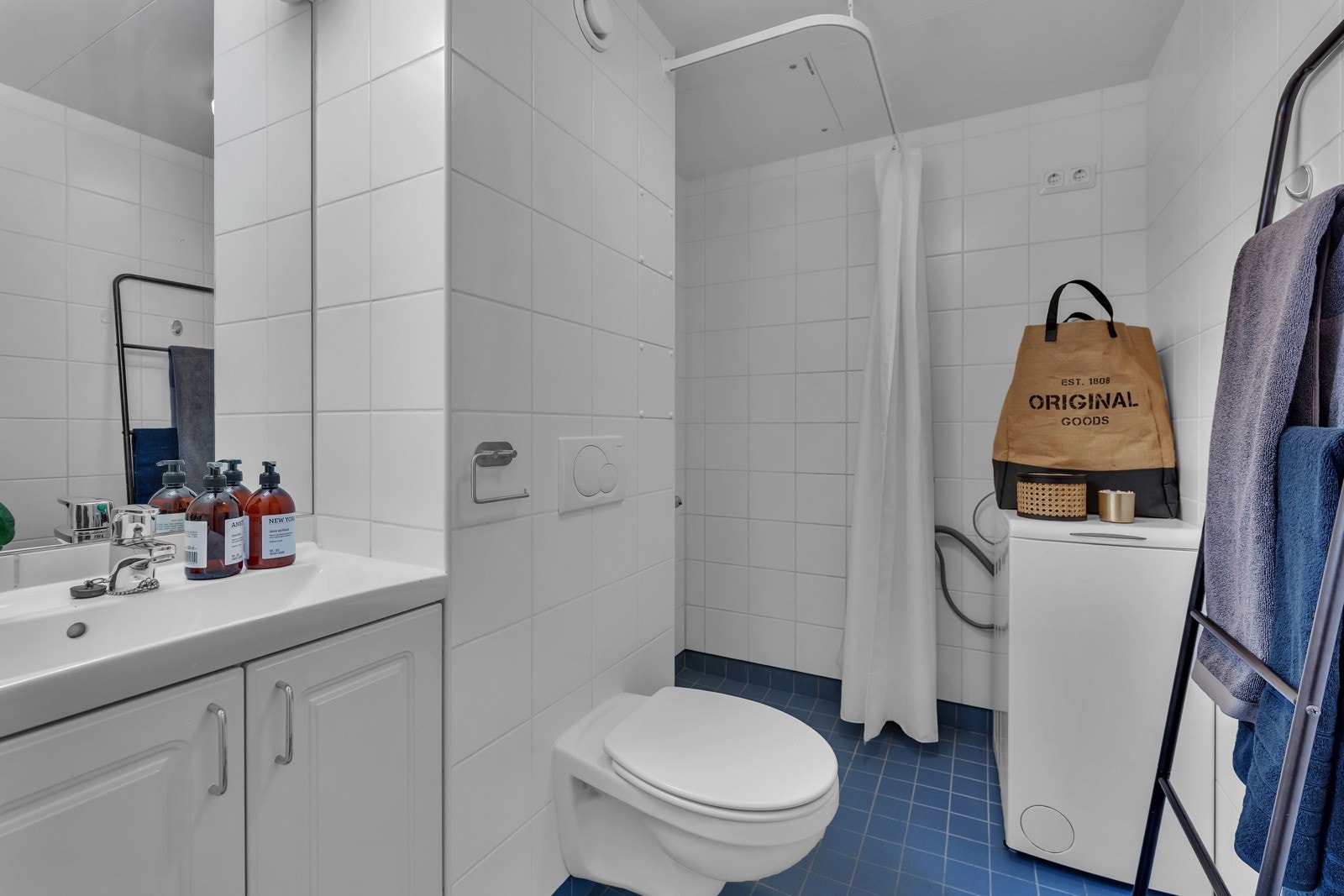 Badet er innredet med velholdte fliser i hvitt og blått, med varme i gulv. Galleribilde