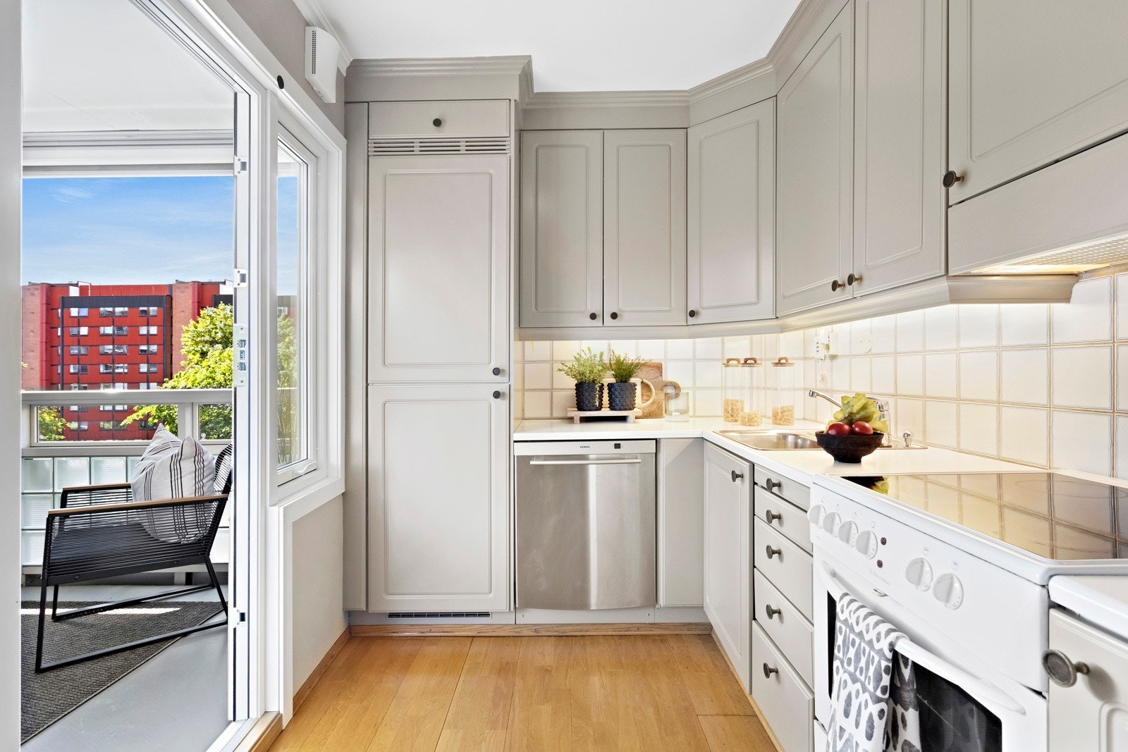 Takhøy kjøkkeninnredning med integrert kjøl- og fryseskap hvor ytterligere hvitevarer er frittstående. Galleribilde