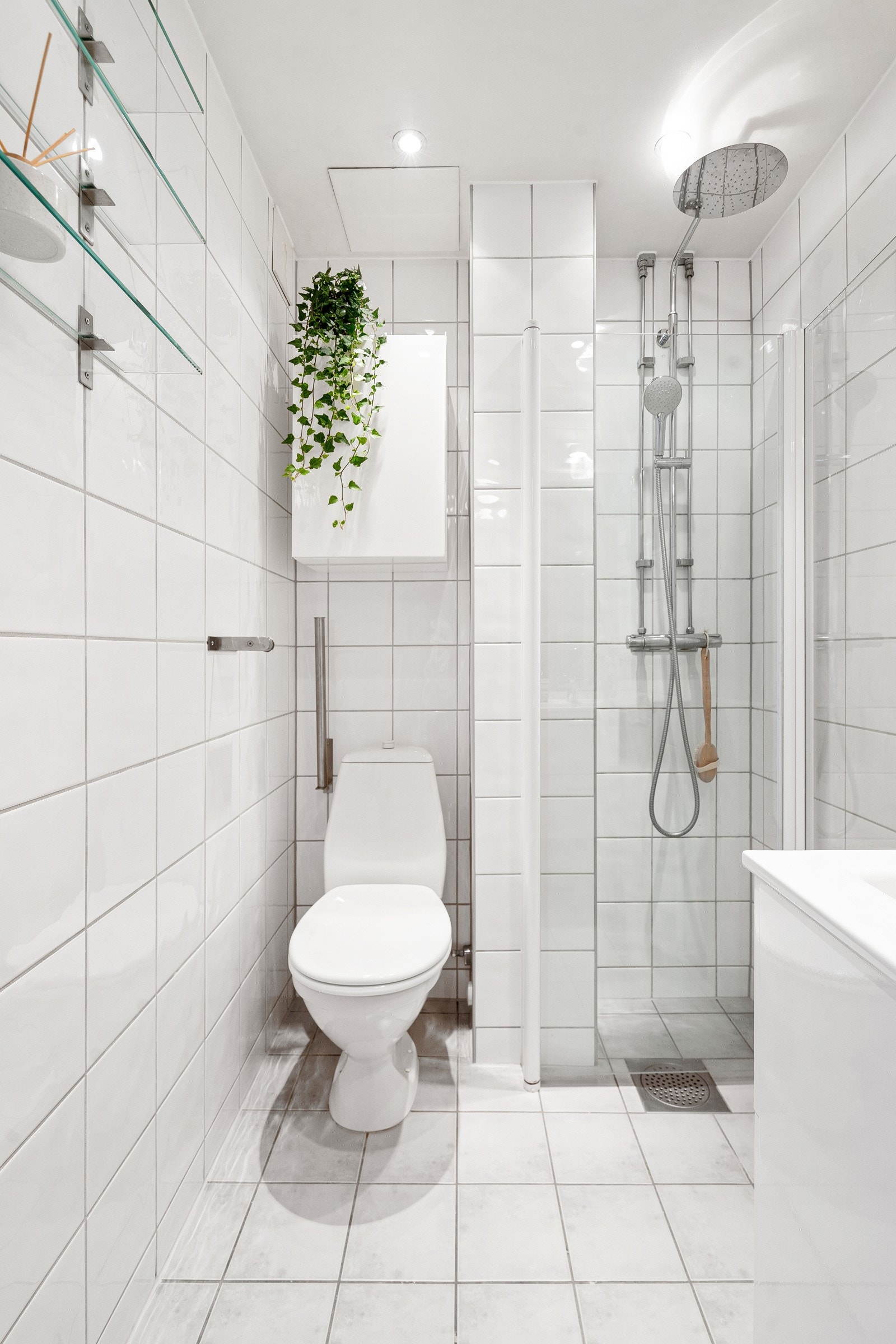 Gulvmontert WC, samt dusjnisje med innfellbare glassdører og dusjarmatur tilkoblet hånddusj og regnfallsdusj. Galleribilde